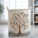 Cream quilted storage basket with an embroidered tree in full bloom in gold, beige and navy tones